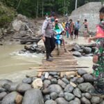 Bhabinkamtibmas Bersama Warga Perbaiki Jembatan Putus